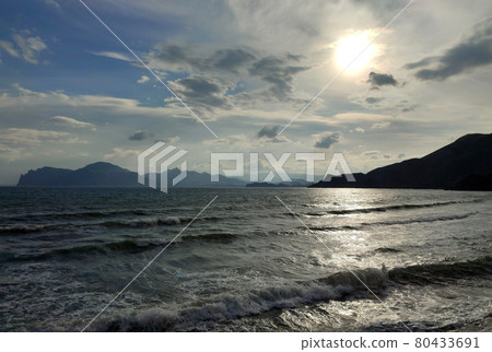Wonderful sunset on a raging seashore with mountains 80433691