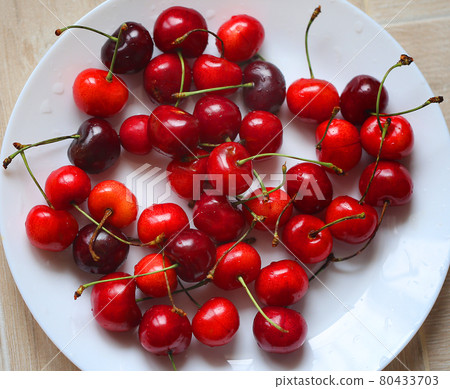 Red ripe macro cherries on a plate 80433703