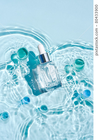 Mockup of cosmetic glass blue bottle with pipette and serum on water surface with waves. Advertising of medical product anti-aging moisturizing care Mockup of cosmetic glass blue bottle with pipette and serum on water surface with waves. Advertising of medical product anti-aging moisturizing care 80433900