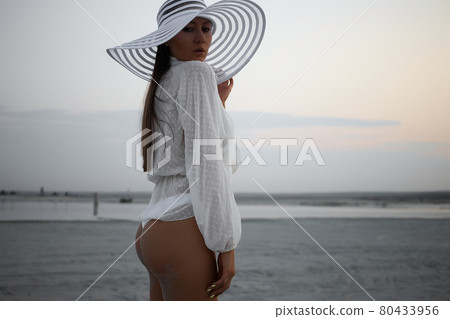 Stylish sensual woman in beachwear and hat Stylish sensual woman in beachwear and hat 80433956