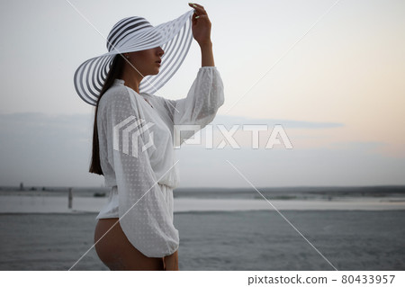 Stylish sensual woman in beachwear and hat 80433957