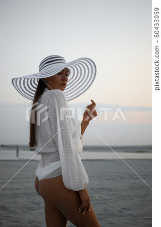 Stylish sensual woman in beachwear and hat 80433959
