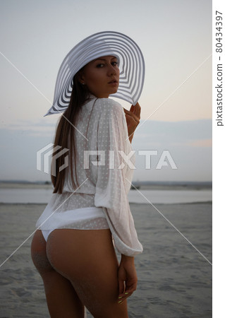 Stylish sensual woman in beachwear and hat Stylish sensual woman in beachwear and hat 80434397