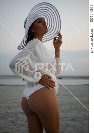 Stylish sensual woman in beachwear and hat Stylish sensual woman in beachwear and hat 80434398