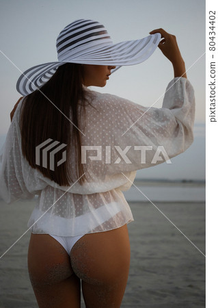 Stylish sensual woman in beachwear and hat Stylish sensual woman in beachwear and hat 80434402