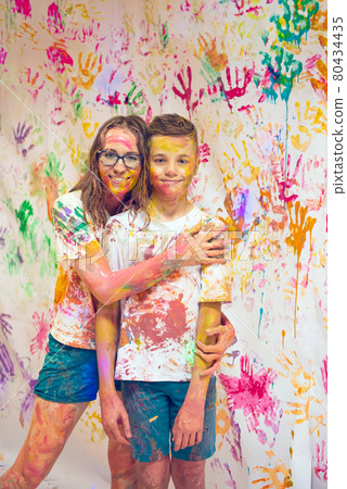 Portrait of a cute happy woman with her son painting and having fun Portrait of a cute happy woman with her son painting and having fun 80434435