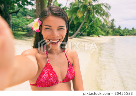Selfie girl taking picture on travel holiday in tropical vacation destination. Asian woman holding mobile photo to take self-portrait photo at luxury Bora Bora island getaway Selfie girl taking picture on travel holiday in tropical vacation destination. Asian woman holding mobile photo to take self-portrait photo at luxury Bora Bora island getaway 80435588