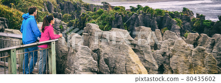New zealand tourism lifestyle. Punakaiki Pancake Rocks tourists couple travel in Paparoa National Park, West Coast, South Island, New Zealand. Panoramic banner. New zealand tourism lifestyle. Punakaiki Pancake Rocks tourists couple travel in Paparoa National Park, West Coast, South Island, New Zealand. Panoramic banner. 80435602