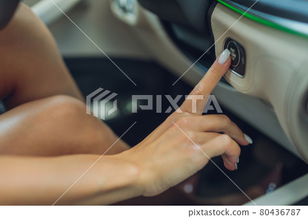 Female hand with start key inside car. 80436787