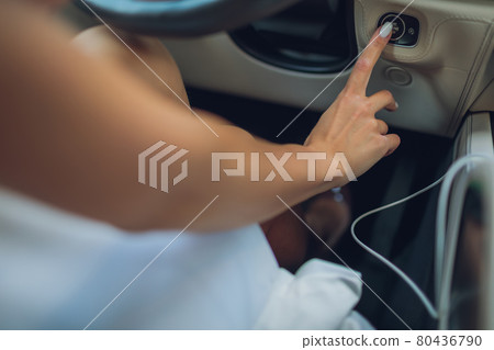 Female hand with start key inside car. 80436790