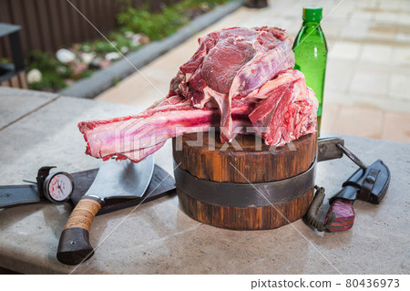 Raw meat on a deck for making lunch. Fresh meat on a cutting board with olive oil and a knife. Raw meat on a deck for making lunch. Fresh meat on a cutting board with olive oil and a knife. 80436973