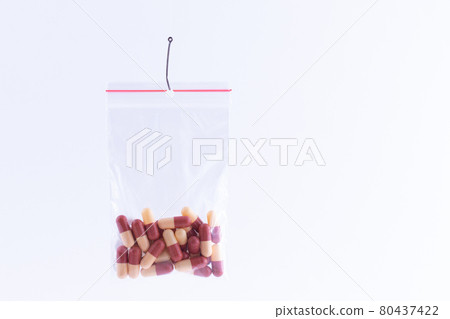 Colored Pills or Tablets Hanging in Small Ziplock Bag on a Fishing Hook Colored Pills or Tablets Hanging in Small Ziplock Bag on a Fishing Hook 80437422
