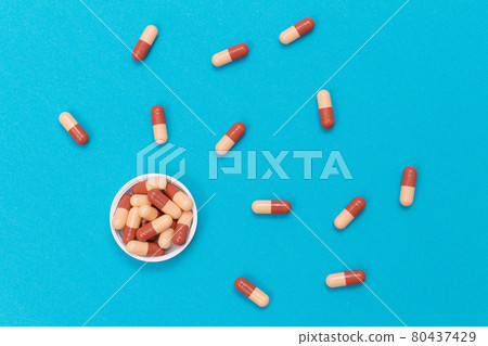 Pharmaceutical Industry and Medicinal Products - Colored Pills on Blue Table Pharmaceutical Industry and Medicinal Products - Colored Pills on Blue Table 80437429