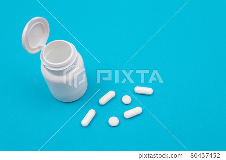 Pharmaceutical Industry and Medicinal Products - White Pills on Blue Table Pharmaceutical Industry and Medicinal Products - White Pills on Blue Table 80437452