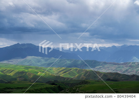 Grassland and mountains in a cloudy day. Photo in Kalajun grassland in Xinjiang, China. 80439404