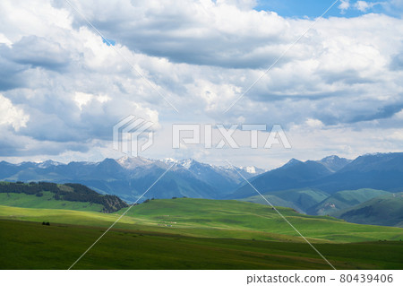 Grassland and mountains in a cloudy day. Photo in Kalajun grassland in Xinjiang, China. 80439406