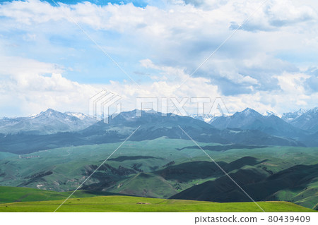 Grassland and mountains in a cloudy day. Photo in Kalajun grassland in Xinjiang, China. Grassland and mountains in a cloudy day. Photo in Kalajun grassland in Xinjiang, China. 80439409