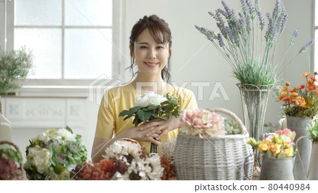 A woman enjoying a flower arrangement A woman enjoying a flower arrangement 80440984