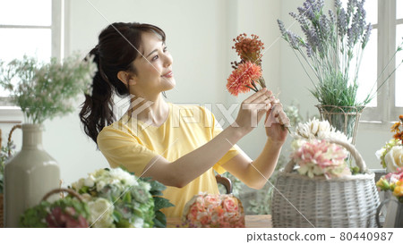 A woman enjoying a flower arrangement A woman enjoying a flower arrangement 80440987