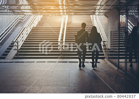 Silhouettes of people. People in underground crossing. View from the back. Couple of young people on the crosswalk. The couple is holding hands and walking on the sity. Unknown people. Street photo Silhouettes of people. People in underground crossing. View from the back. Couple of young people on the crosswalk. The couple is holding hands and walking on the sity. Unknown people. Street photo 80442837