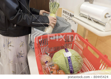 A woman's bagger that packs products purchased at a supermarket into my bag A woman's bagger that packs products purchased at a supermarket into my bag 80445424