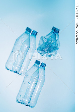 Plastic bottles with water and empty used on blue background. Recycling recyclable plastic. Environmental protection Plastic bottles with water and empty used on blue background. Recycling recyclable plastic. Environmental protection 80447419