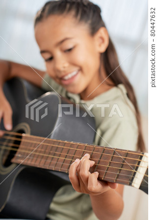Girl learning to play guitar Girl learning to play guitar 80447632