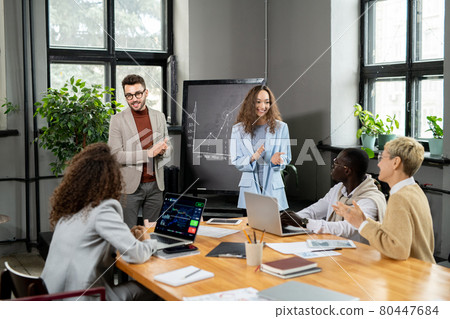 Happy businesspeople congratulating colleagues on successful presentation Happy businesspeople congratulating colleagues on successful presentation 80447684