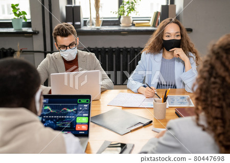 Group of managers in protective masks working in office Group of managers in protective masks working in office 80447698