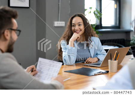 Happy young businesswoman listening to male speaker Happy young businesswoman listening to male speaker 80447743
