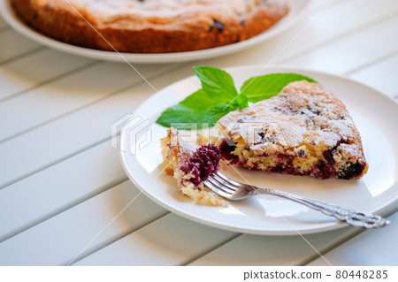 Piece of homemade simple pie with fresh red raspberries and black mulberry on a light background. Summer berry dessert. close up Piece of homemade simple pie with fresh red raspberries and black mulberry on a light background. Summer berry dessert. close up 80448285
