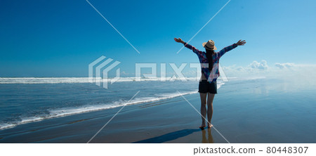 A woman who spreads her hands at the sea 80448307