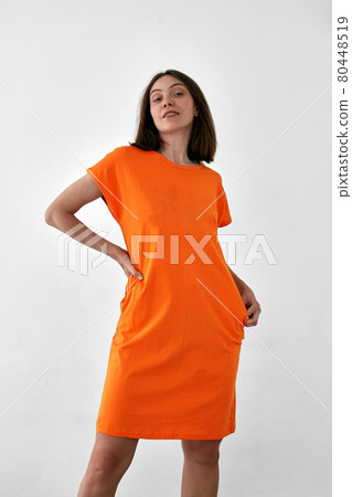 Pretty woman in orange dress white background Pretty woman in orange dress white background 80448519