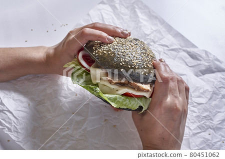 Eating black burger 80451062