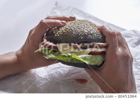 Eating black burger 80451064