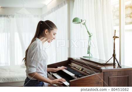 Happy Caucasian young woman playing electric piano,Happy and smiling,Relaxing time 80451082