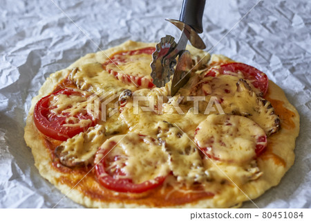 Cutting homemade pizza 80451084