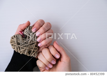 Healthy woman's hands with heart decoration. Nude nails. Clean skin. Soft light. Good for cosmetics. Natural colors, retouch. Long elegant fingers. Self care 80452399