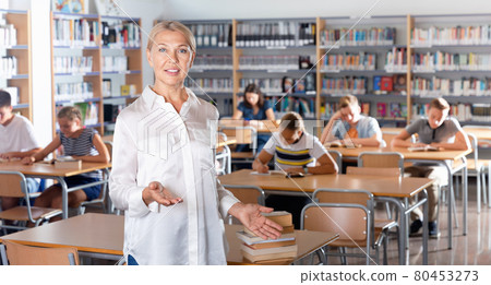 Portrait of mature woman teacher standing in classroom Portrait of mature woman teacher standing in classroom 80453273
