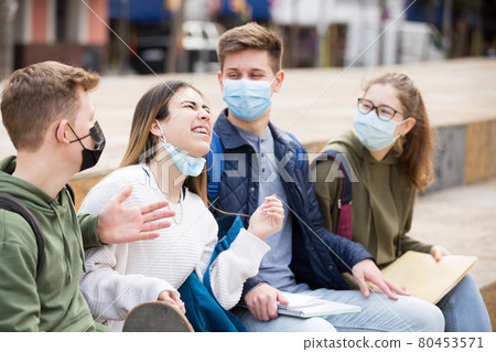 Teenagers in face masks talking outdoors Teenagers in face masks talking outdoors 80453571
