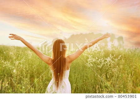 Young woman spreading hands to the sides and facing to the sun 80453901