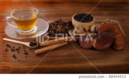 Tea, lingzhi, black pepper, cinnamon, star anise on wood 80454413
