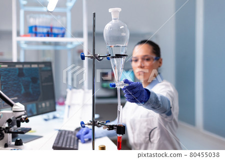 Microbiologist researcher woman examining blood test results working at biochemistry virus experiment 80455038