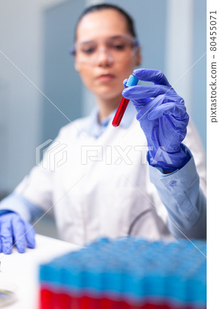 Specialist woman doctor holding blood medical vacutainer analyzing dna infection expertise Specialist woman doctor holding blood medical vacutainer analyzing dna infection expertise 80455071