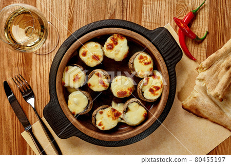 Baked mushrooms caps stuffed with sulguni in wooden bowl Baked mushrooms caps stuffed with sulguni in wooden bowl 80455197