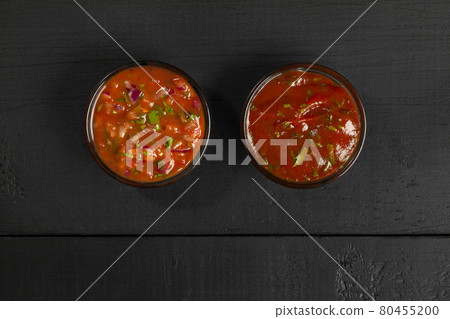 Tomato sauces in glass dipping bowls on black wooden background 80455200