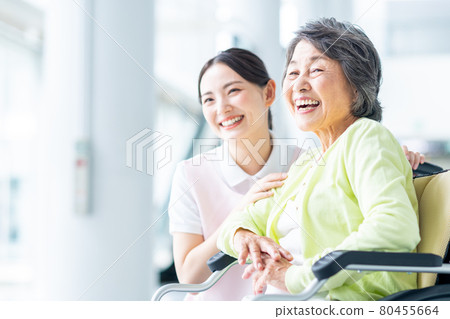 Elderly and young care staff in wheelchairs 80455664