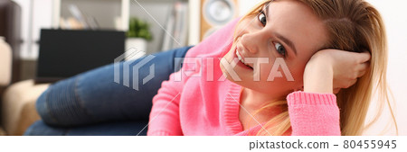 young pretty blond womansit on sofa hold smartphone in hands 80455945