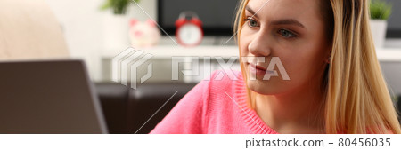 young beautiful blond woman sit in livingroom work on laptop 80456035