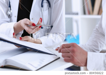 Female doctor hand hold silver pen and showing pad 80456822